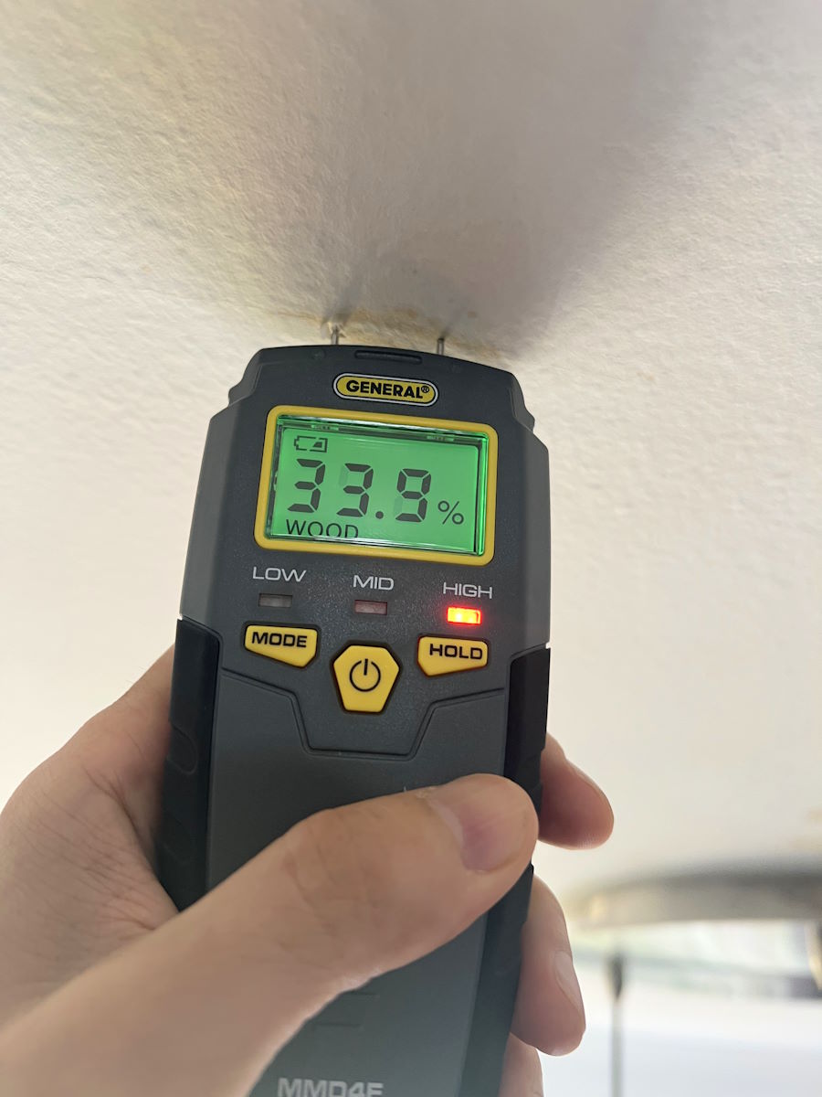 A moisture meter confirms there is a leak on the level above