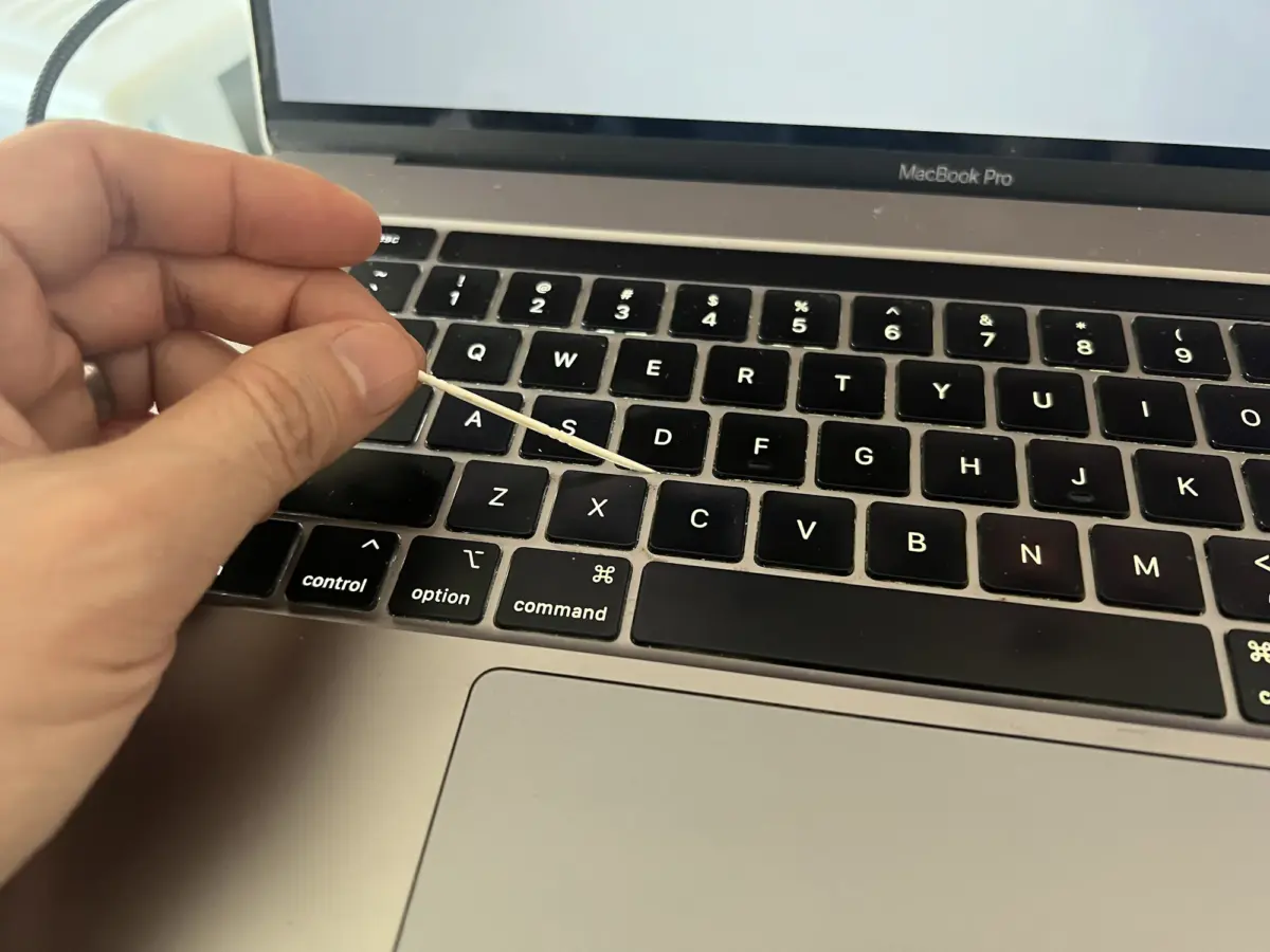 Cleaning around a Macbook's keys with The Doctor's BrushPicks